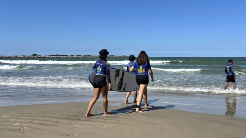 Escola de Surf Atalaia Itajaí,surf feminino Itajaí SC,Projeto Itajaí Surf,inclusão social através do esporte,surf para crianças Itajaí,Praia do Atalaia surf,esporte em Itajaí Santa Catarina,mulheres no surf Santa Catarina,projeto social surf Itajaí,educação e esporte Itajaí SC,jovens surfistas Itajaí,incentivo ao esporte feminino SC,surf feminino Brasil crescimento,iniciativas esportivas Itajaí,esporte e inclusão social Santa Catarina