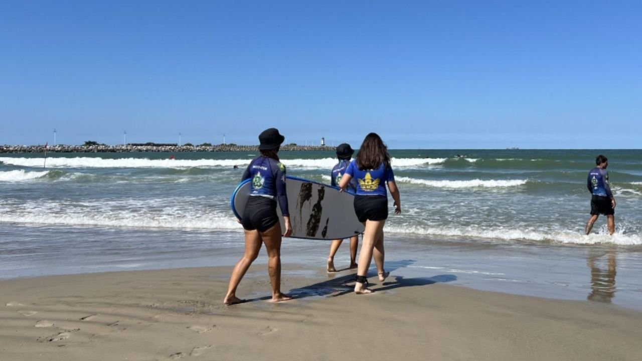 Escola de Surf Atalaia Itajaí,surf feminino Itajaí SC,Projeto Itajaí Surf,inclusão social através do esporte,surf para crianças Itajaí,Praia do Atalaia surf,esporte em Itajaí Santa Catarina,mulheres no surf Santa Catarina,projeto social surf Itajaí,educação e esporte Itajaí SC,jovens surfistas Itajaí,incentivo ao esporte feminino SC,surf feminino Brasil crescimento,iniciativas esportivas Itajaí,esporte e inclusão social Santa Catarina