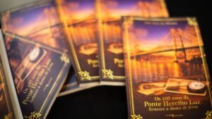 Ponte Hercílio Luz 100 anos,livro Ponte Hercílio Luz Florianópolis,história Florianópolis SC,José Braz da Silveira autor,centenário ponte SC,Alesc evento cultural,patrimônio histórico Santa Catarina,desenvolvimento urbano Florianópolis,história década 1920 SC,cultura catarinense livro,infraestrutura histórica Brasil,símbolo Florianópolis ponte,lançamento livro SC,memória histórica Santa Catarina,literatura regional SC