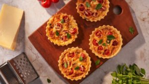 Mini Quiche Caprese,receita de mini quiche,quiche caprese,receita italiana,culinária italiana,aperitivo sofisticado,entrada gourmet,receita com muçarela,receita com tomate-cereja,receita com manjericão,quiche fácil,mini quiche caseira,receita para festas,receita de aperitivo,quiche de queijo,massa para quiche,creme para quiche,receitas especiais,gastronomia italiana,receita para receber convidados,mini quiche assada,receita gourmet